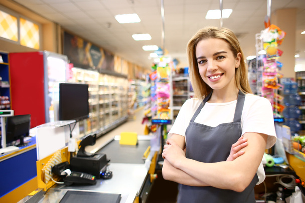 Portrait of female cashier in supermarket - Photo, Image