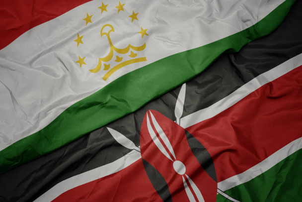 κυματίζει πολύχρωμη σημαία του kenya και εθνική σημαία του Τατζικιστάν. - Φωτογραφία, εικόνα