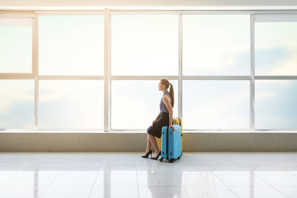 Młoda bizneswoman z walizkami w holu lotniska - Zdjęcie, obraz