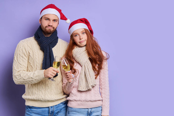 redhaired woman and unshaven man in satna claus hat - Фото, изображение