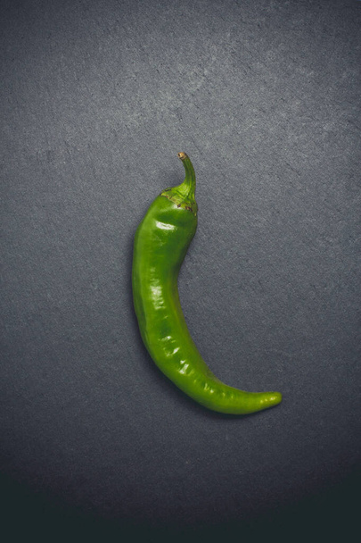 Hot peppers voor kruidige gerechten op een zwarte achtergrond - Foto, afbeelding