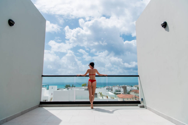 Sommerurlaub im Luxushotel, Frau entspannen in der Nähe des schönen Swimmingpools auf dem Dach. sexy Girl Wearink Bikini genießen Meerblick. Rückseite, ohne Gesicht - Foto, Bild