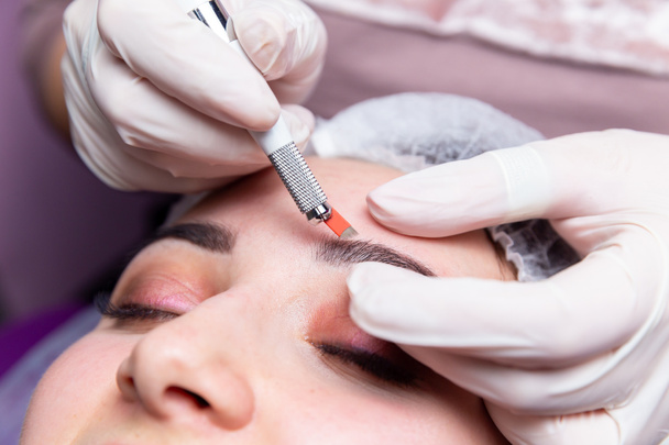 Kosmetische Verfahren zur Behandlung der Augenbrauen. Microblading im Schönheitssalon. Professionelle Kosmetologie. Der Prozess der Anwendung des Pigments - Foto, Bild