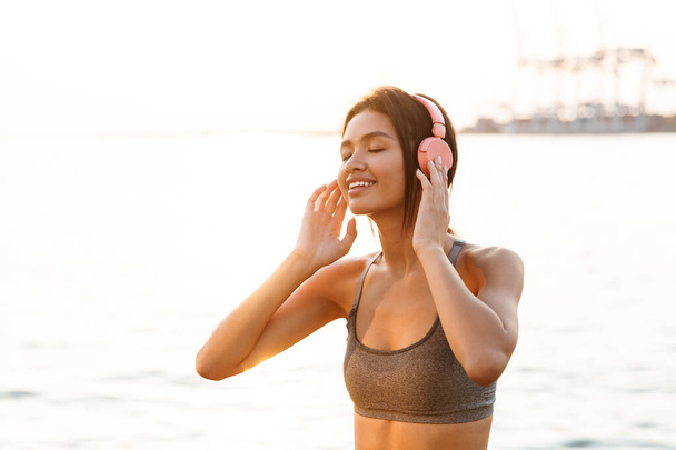 Image of young asian woman listening to music with headphones by - Фото, изображение