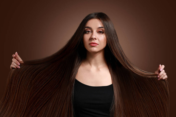 Gyönyörű nő egészséges hosszú haj színes háttér - Fotó, kép