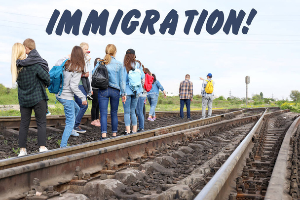 Grupo de inmigrantes ilegales caminando por vías férreas
 - Foto, imagen