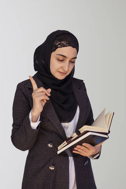 Ładna muzułmańska bizneswoman w hidżabie trzymająca stertę dokumentów biznesowych, notatników i myśli - dobry pomysł. Kobieta robi interesy w islamskich słowach, lub krajach islamskich - Zdjęcie, obraz