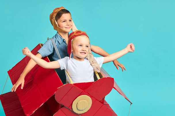 Excited little boys flying on red toy airplane - Photo, Image