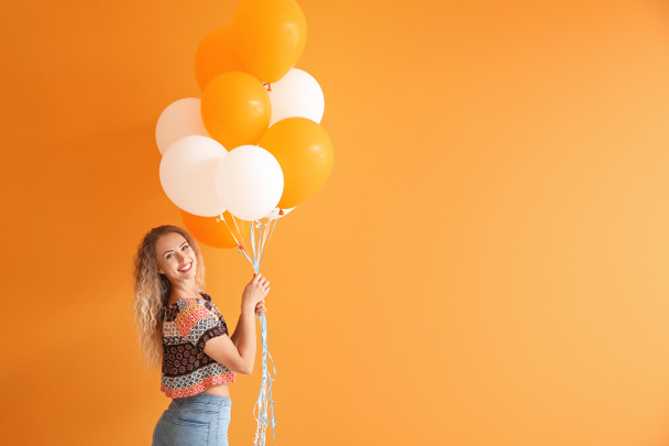 Hermosa mujer joven con globos en el fondo de color - Foto, imagen