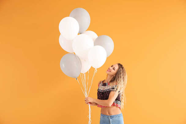 Beautiful young woman with balloons on color background - Photo, Image