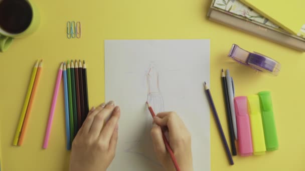 Топ-модельер использует цветные карандаши для рисования наряда
 - Кадры, видео