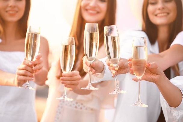 Beautiful young women drinking champagne at hen party outdoors - Фото, зображення