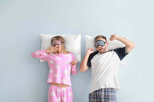 Jeune couple endormi avec des oreillers sur fond de couleur
 - Photo, image