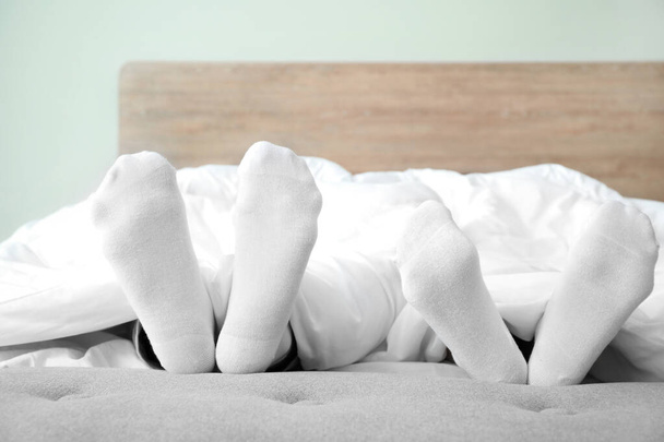 Feet of young couple sleeping in bed - Photo, Image