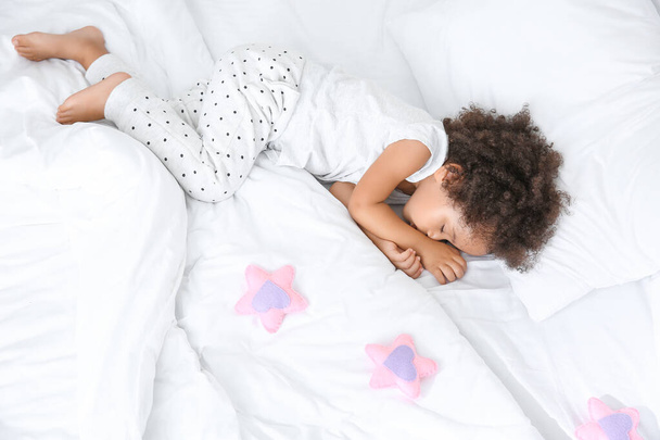 Маленькая афроамериканка спит в постели
 - Фото, изображение
