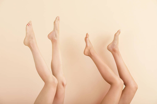 Frauen mit schönen Beinen nach der Enthaarung auf farbigem Hintergrund - Foto, Bild