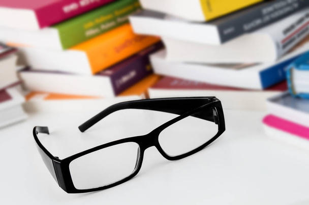Libros y gafas de lectura sobre fondo blanco
 - Foto, imagen