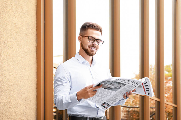 Handsome man with newspaper outdoors - Photo, Image