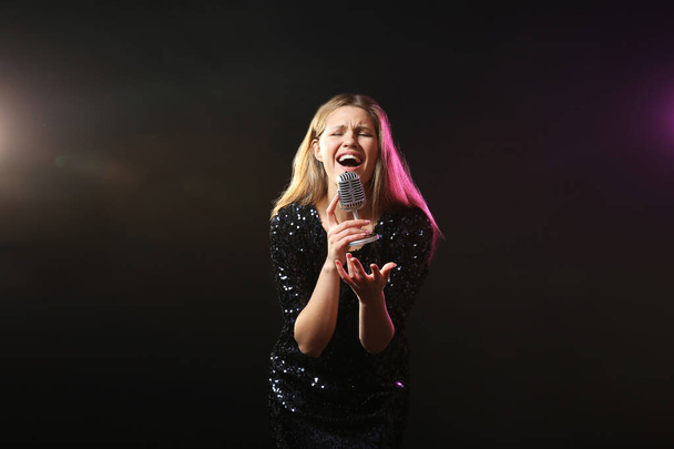 Hermosa joven cantante femenina con micrófono en el escenario
 - Foto, Imagen