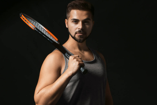 Male tennis player on dark background - Foto, imagen
