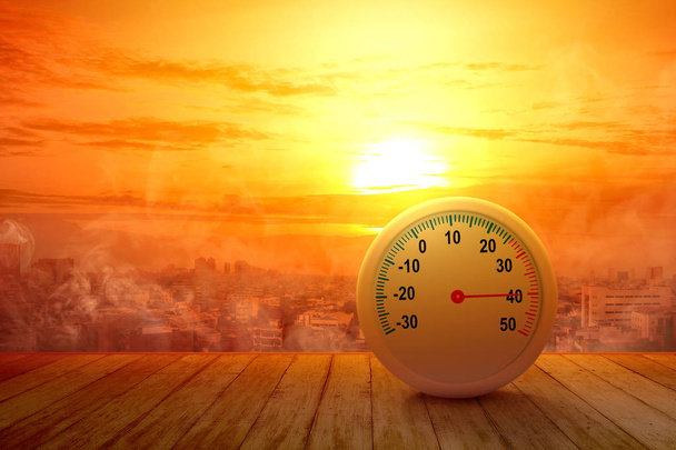 The thermometer on a wooden table with a high temperature on the - Фото, изображение