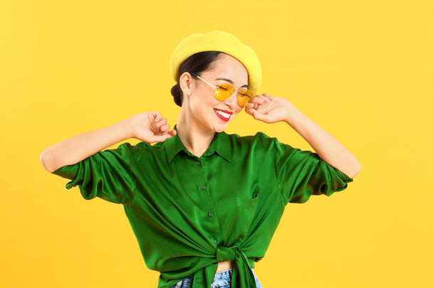 Fashionable Asian woman on color background - Foto, imagen