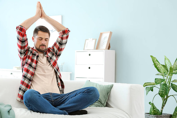 schöner Mann meditiert zu Hause - Foto, Bild