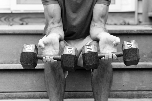 Дорослий чоловік тренується з вільними вагами
 - Фото, зображення