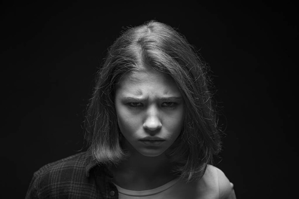 Retrato en blanco y negro de una adolescente triste sobre fondo oscuro
 - Foto, Imagen