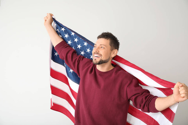 Homem bonito com bandeira dos EUA em fundo claro. Celebração do Dia Memorial
 - Foto, Imagem