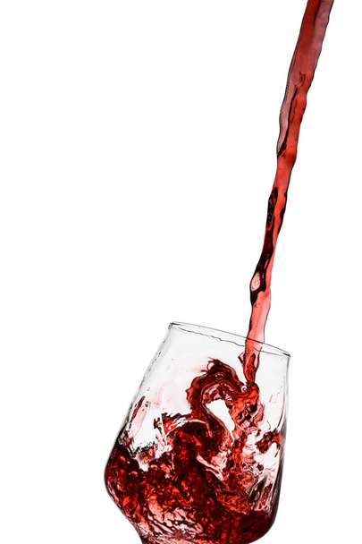 Pouring of red wine into glass on white background - Fotografie, Obrázek