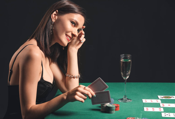 Vrouwelijke pokerspeler aan tafel in casino - Foto, afbeelding