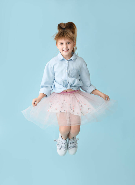Jumping little girl on color background - Fotografie, Obrázek