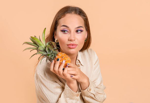 Portret van modieuze jonge vrouw met ananas op kleur achtergrond - Foto, afbeelding