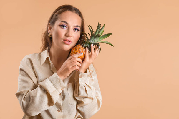 Porträt einer modischen jungen Frau mit Ananas auf farbigem Hintergrund - Foto, Bild
