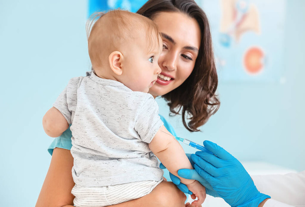 Pediatrician vaccinating little baby in clinic - Photo, image