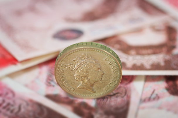Ison-Britannian punnan seteleihin sijoitettu Englannin punnan kolikko
 - Valokuva, kuva
