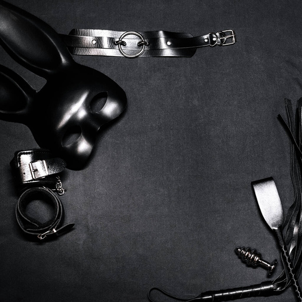 Leather whip, handcuffs, choker, mask and metal anal plug for BDSM sex and role play - Fotoğraf, Görsel