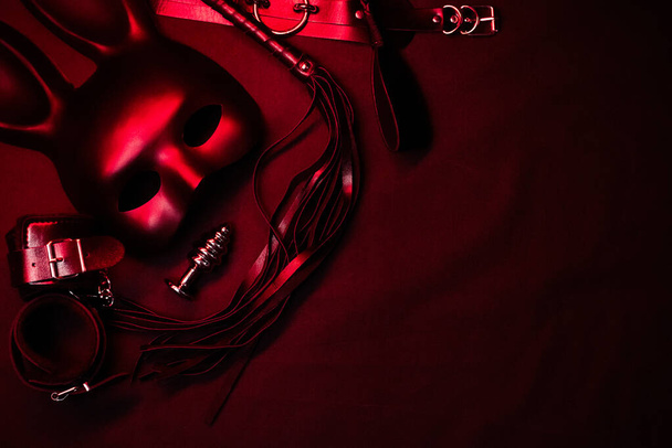 Lederpeitsche, Handschellen, Choker, Maske und Metallanalplug für bdsm Sex mit Unterwerfung und Dominanz - Foto, Bild