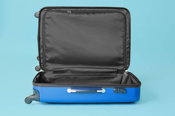 Open empty suitcase on color background - Fotografie, Obrázek