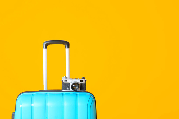 gepackter Koffer und Fotokamera auf farbigem Hintergrund. Reisekonzept - Foto, Bild
