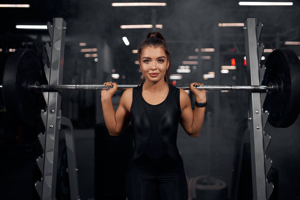 Beautiful weightlifter practicing in gym - Photo, image