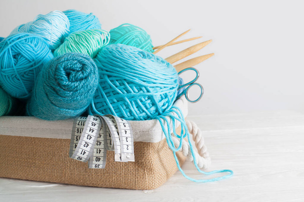  Blue and aquamarin yarn for knitting in a basket. Knitting need - Fotó, kép