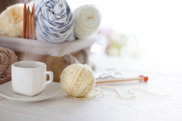 White and beige yarn for knitting in a basket. Knitting needles, - Valokuva, kuva