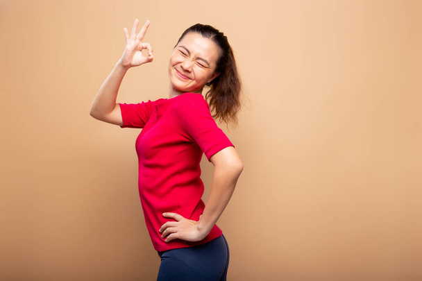 Happy woman showing OK gesture isolated on background - Photo, Image