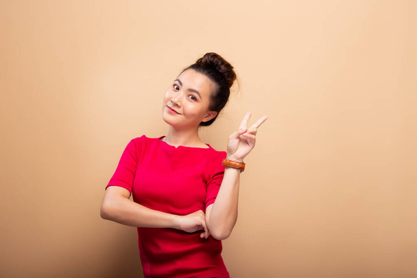 Portrait of happy woman smile and showing peace sign with finger - Photo, Image