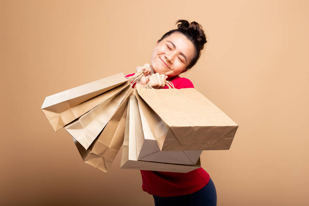 Portrait of woman holding shopping bags isolated over background - Foto, imagen