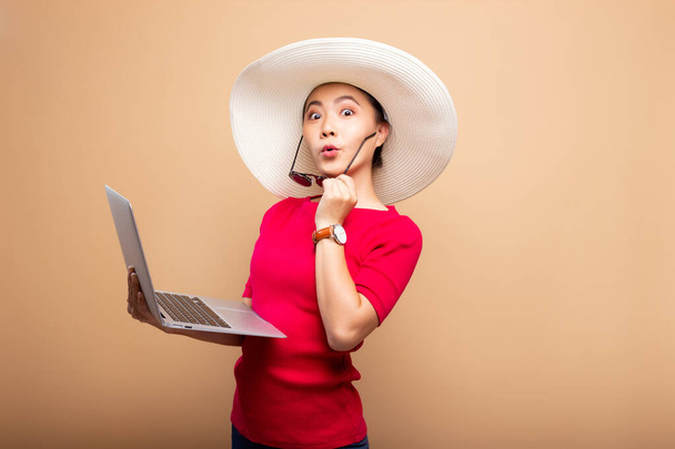 Vrouw met hoed en zonnebril gebruik laptop geïsoleerd op backgrou - Foto, afbeelding