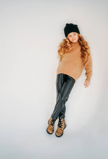 Beauty fashion portrait of smiling curly hair tween girl in black hat and beige sweater on white background isolated - Φωτογραφία, εικόνα