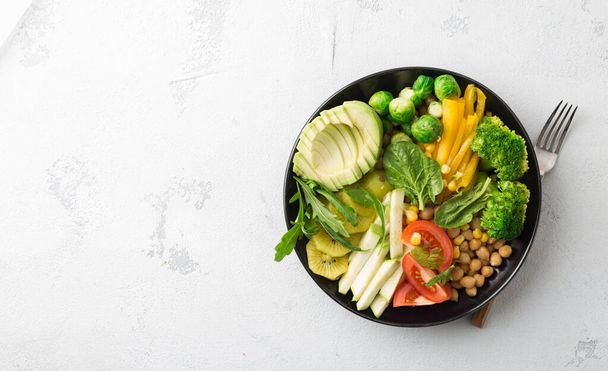 Healthy food nutritionist concept. Healthy vegetable lunch of chickpeas, broccoli, pepper, tomato, spinach, brussel sprouts, arugula and avocado. Top view. Copy space - Foto, Imagem